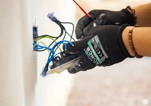 Electrician wiring a wall outlet box